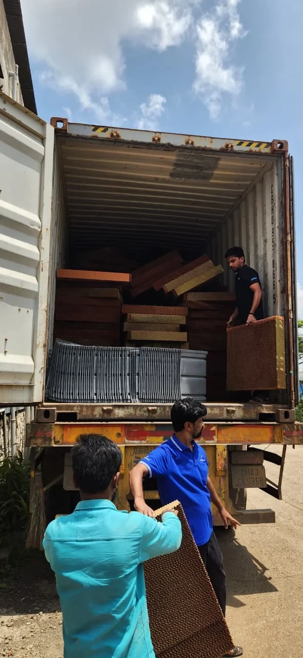 Ayzair staff loading cooling pads and cooler bases into a shipping container at the Pune factory