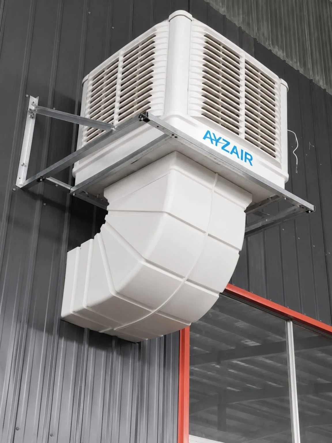 Close view of an Ayzair ductable cooler on a galvanised bracket with the bend pipe passing through the wall cladding