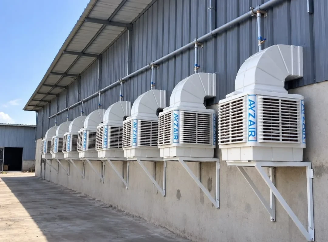 A row of wall-mounted Ayzair ductable evaporative coolers on a factory shed